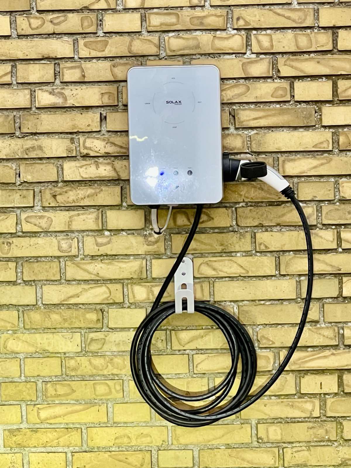 Ladestander på mur med kabelholder